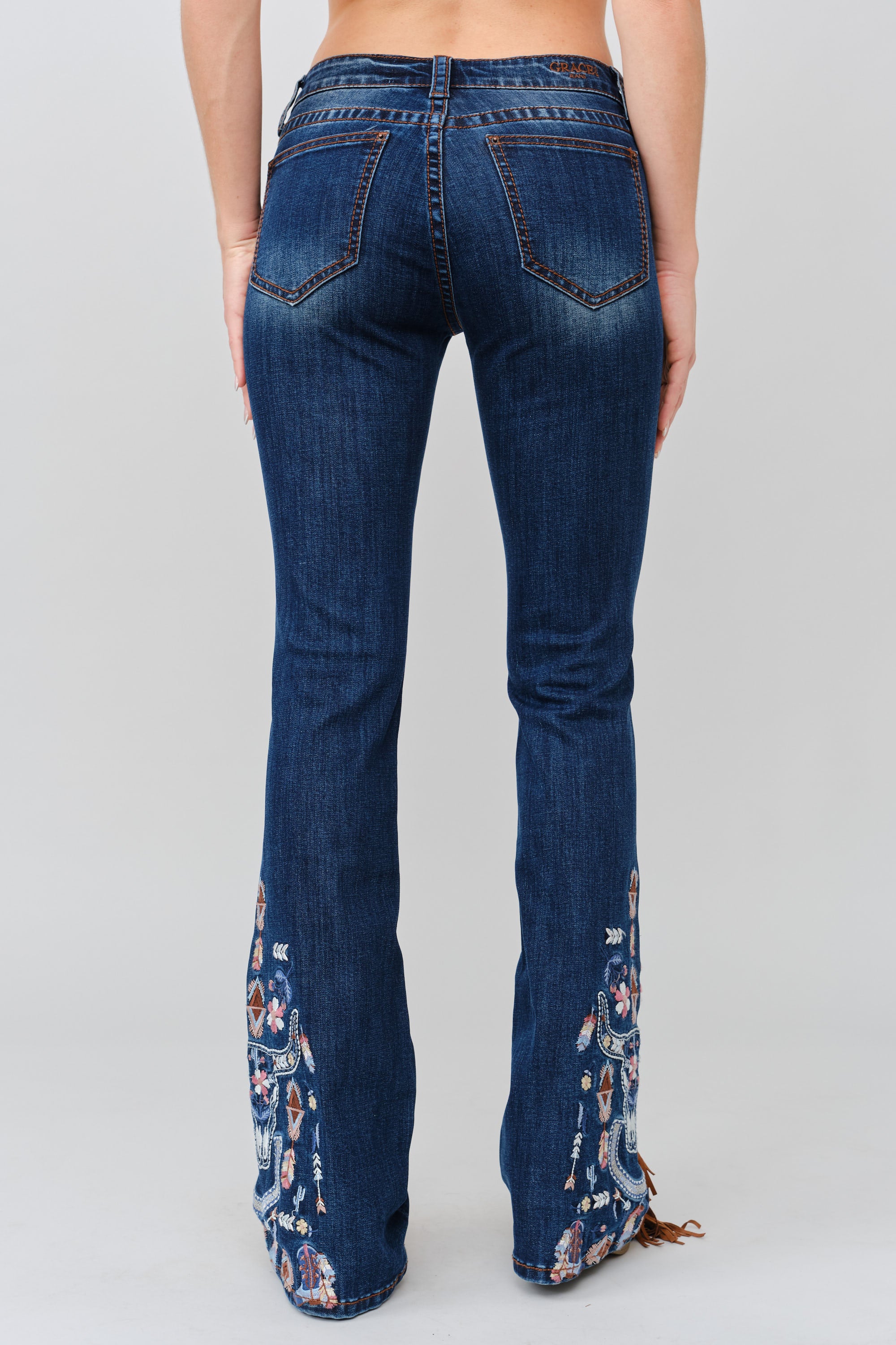 Grace in LA women's medium wash bootcut jeans, full-length rear back view showing embroidered back pockets