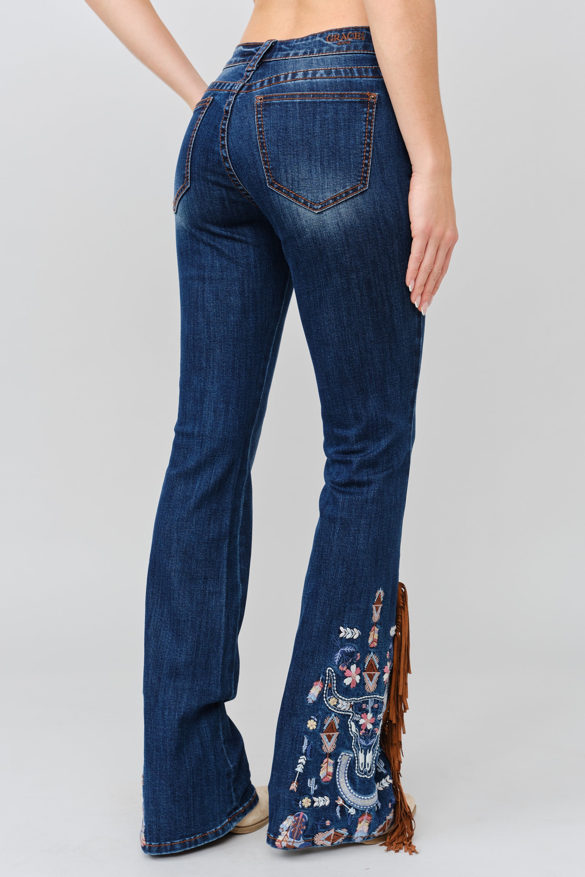Grace in LA women's medium wash bootcut jeans, side-facing view with a fitted silhouette and subtle leg flare