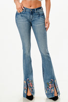 Grace in LA womens flare jeans in a medium blue with colorful floral embroidery on the split hem.