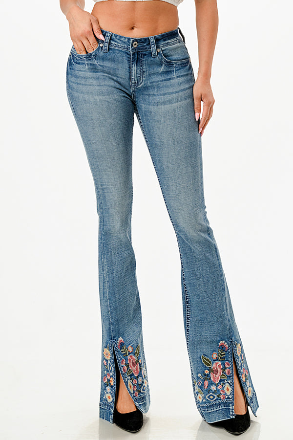 Grace in LA womens flare jeans in a medium blue with colorful floral embroidery on the split hem.