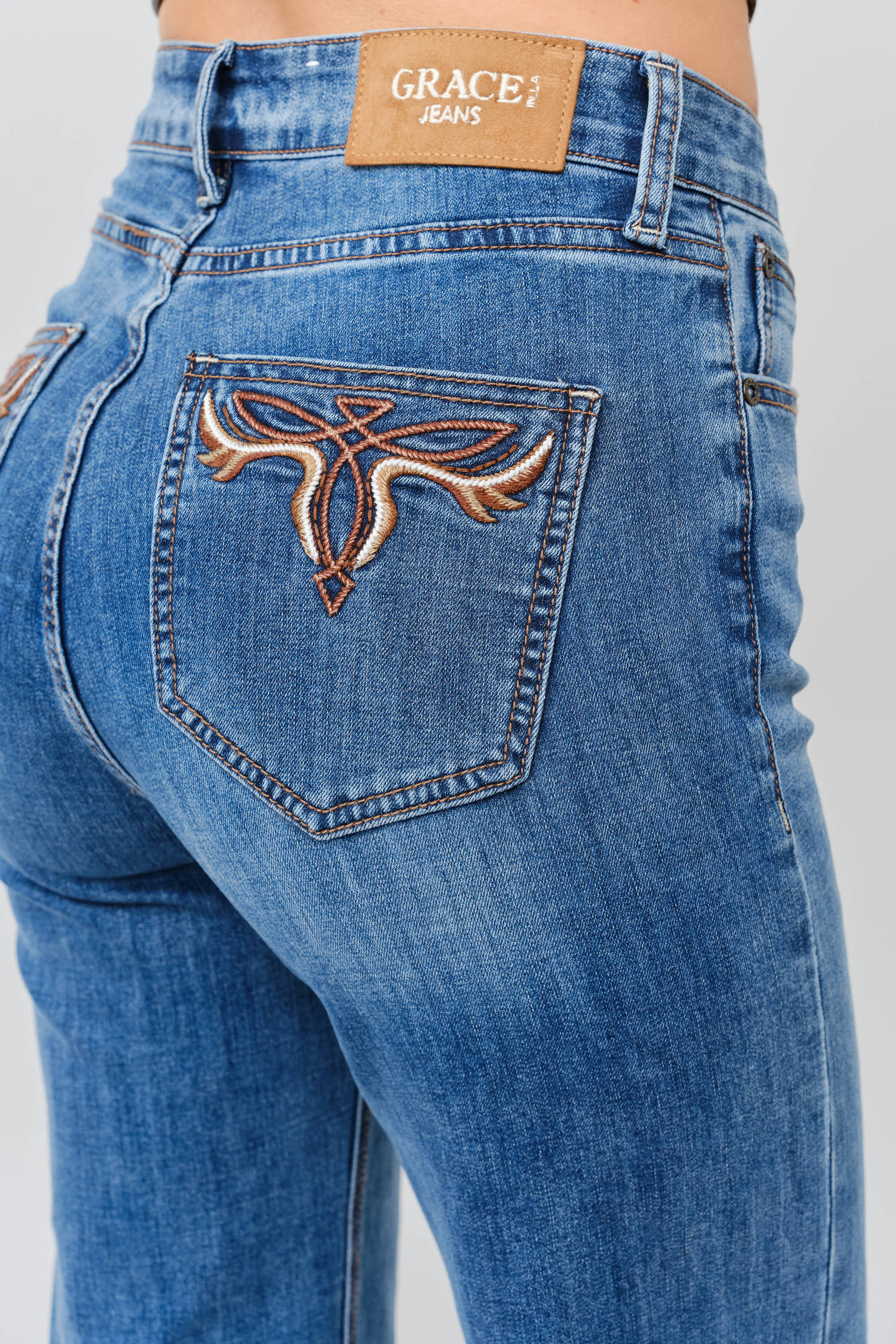 Grace in LA women's medium wash flare jeans, close-up rear view showing the embroidered back pocket detail