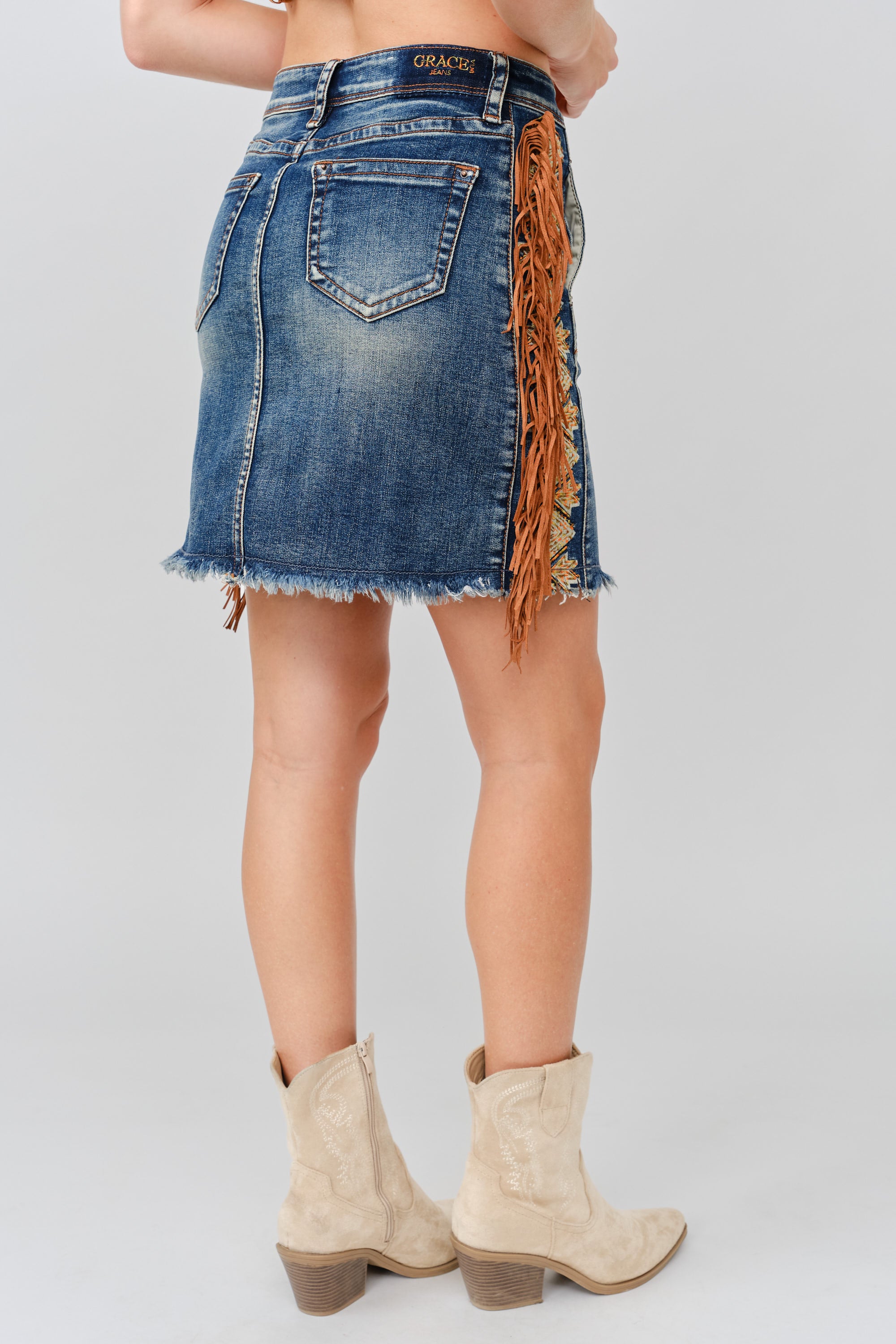 Grace in LA denim skirt close-up of tassel fringe embroidery detailing