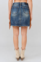 Grace in LA women's medium wash denim skirt side-angle view with tassel fringe detailing