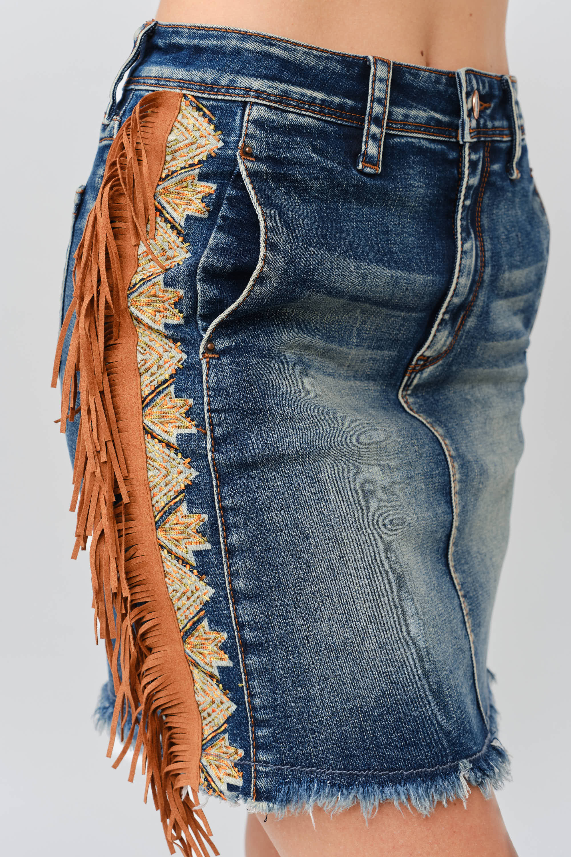 Grace in LA women's medium wash tassel fringe embroidered denim skirt styled for a western-inspired look