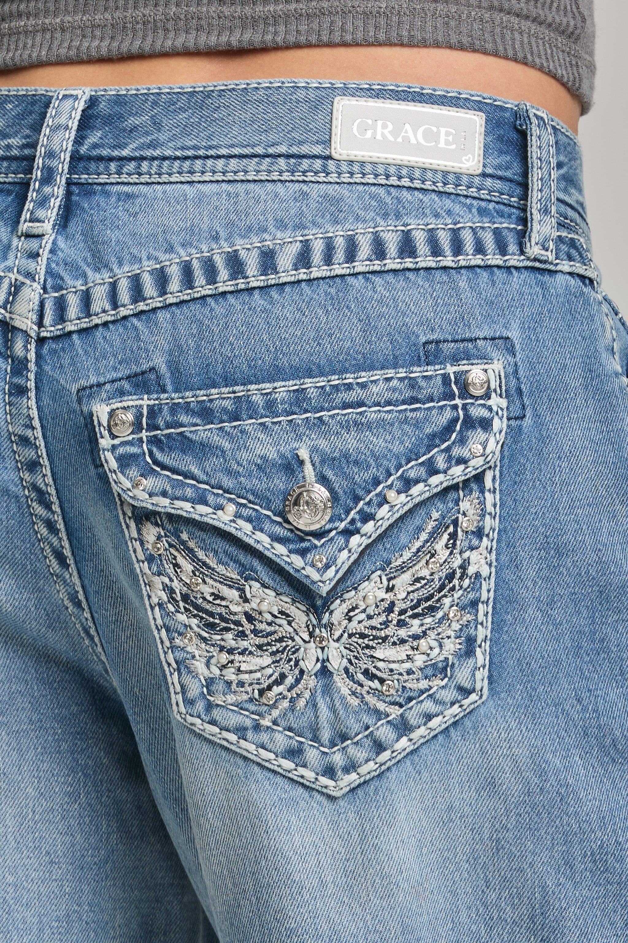 Grace in LA women’s light wash jeans with embellished wing design back pocket