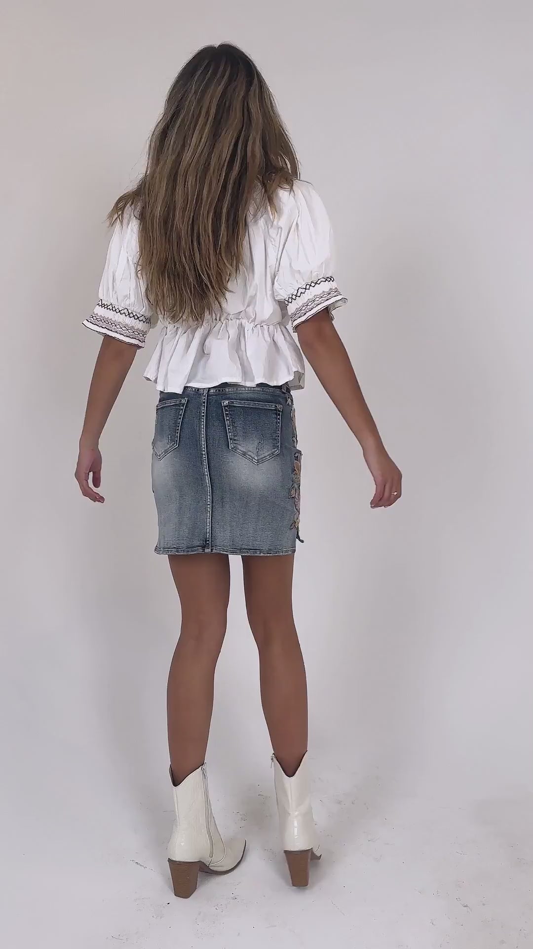 Grace in LA denim mini skirt for women featuring heavy distressing, frayed hem, and western-style embellished back pockets.