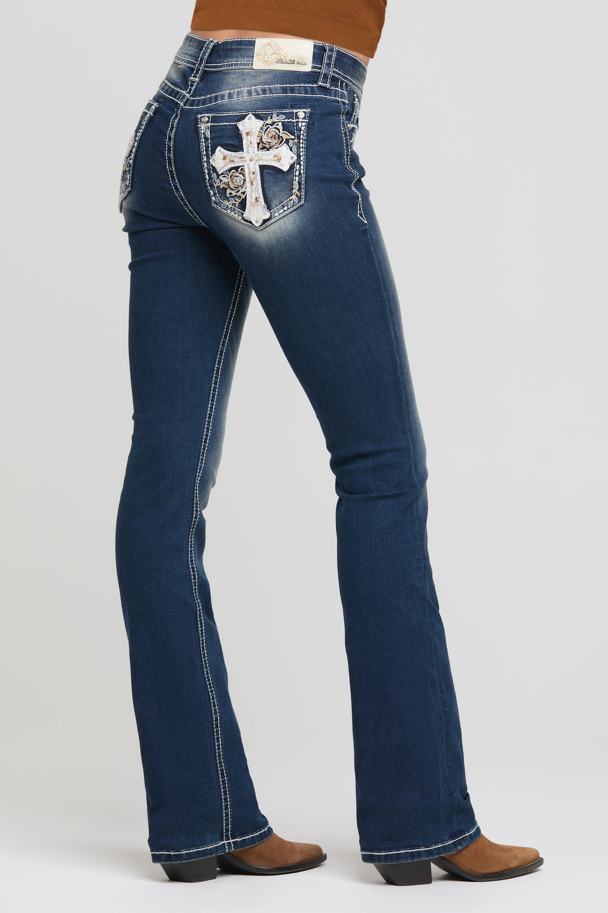 Grace in LA women's medium wash bootcut jeans, front-facing view with cross and floral leather appliqué