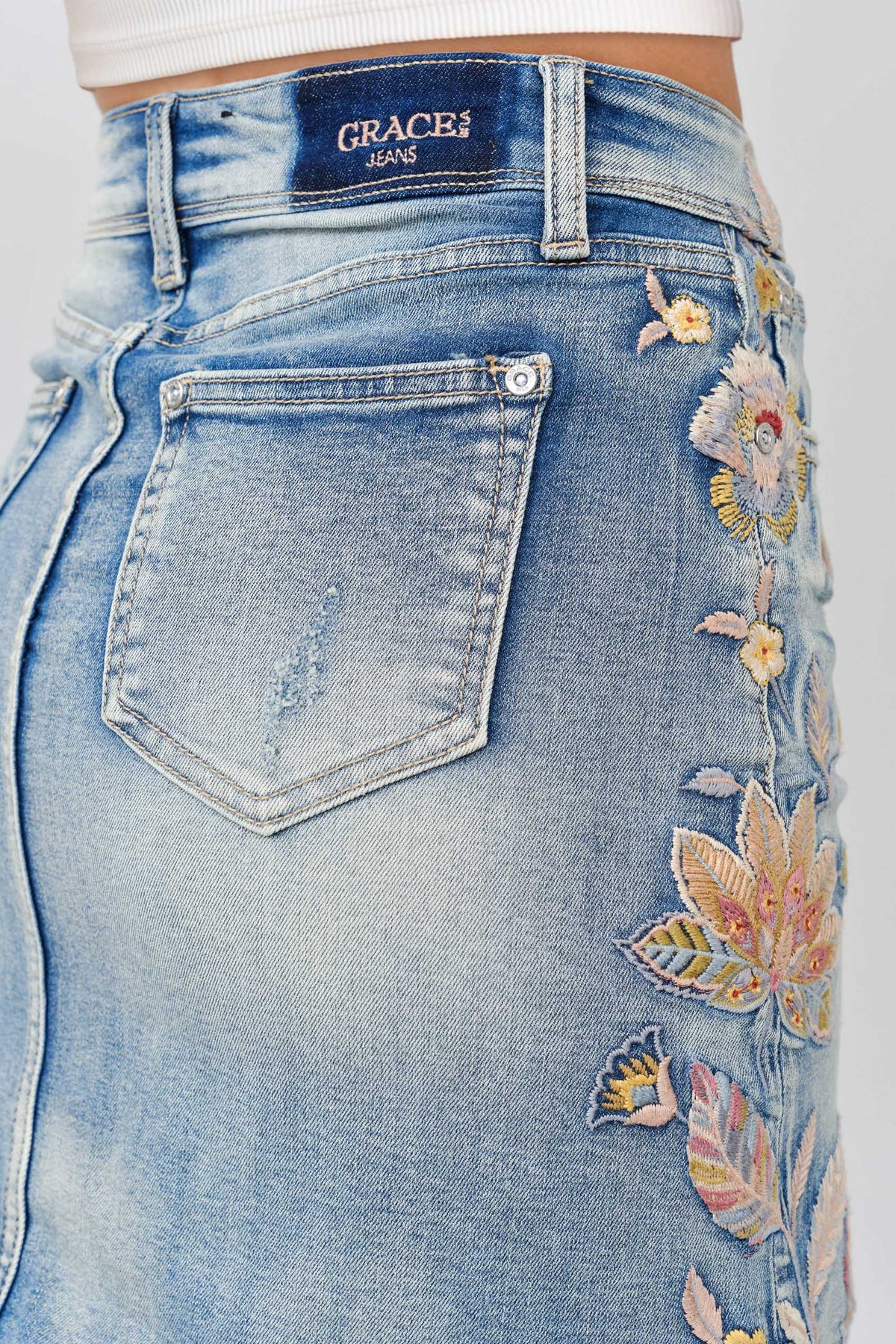 Grace in LA denim skirt back pocket detail featuring floral colored embroidery