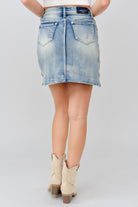 Grace in LA denim skirt close-up of floral colored embroidery on light wash denim
